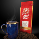 Red Cigar Chief coffee bag beside a blue mug of coffee and roasted beans.